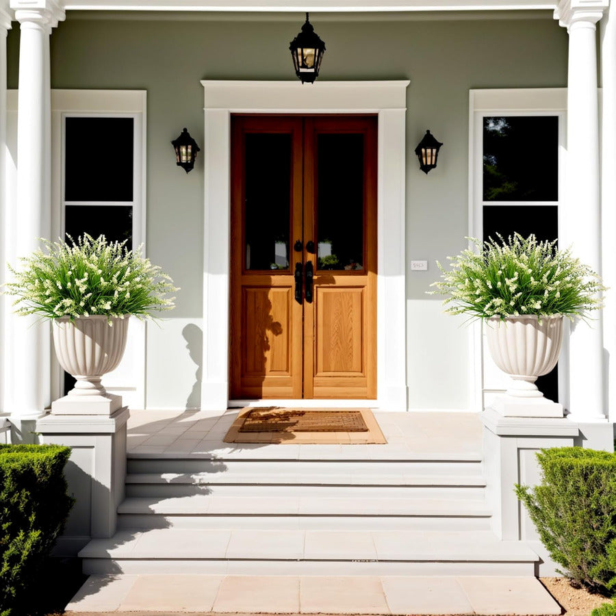 White faux monkey grass planters framing a front porch