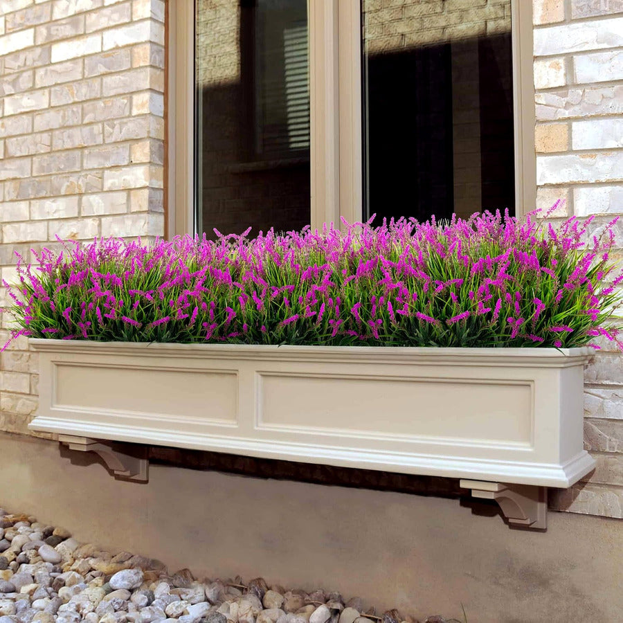 Pink faux monkey grass in a long window box
