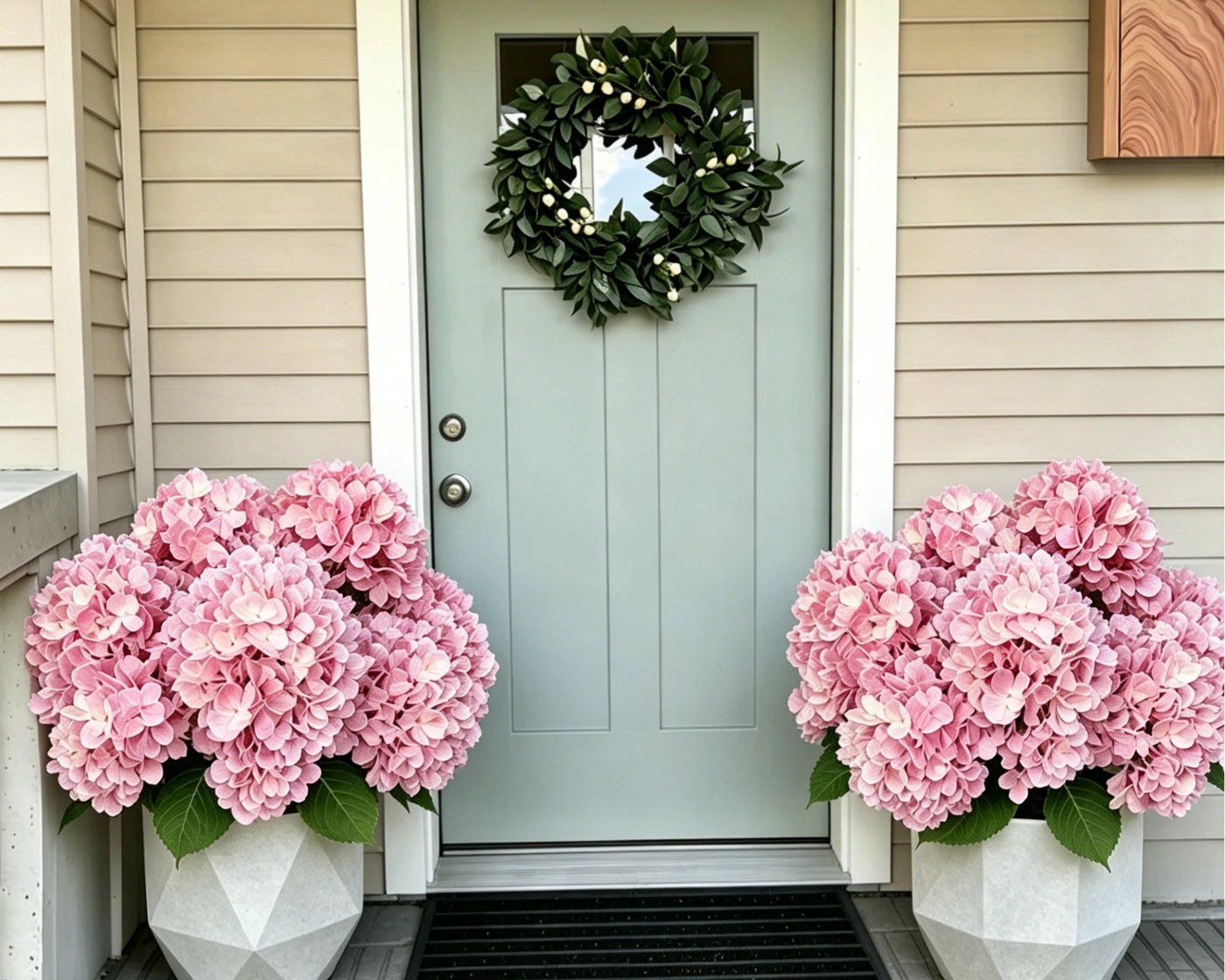 Pink artificial hydrangeas arranged on both sides of a front door