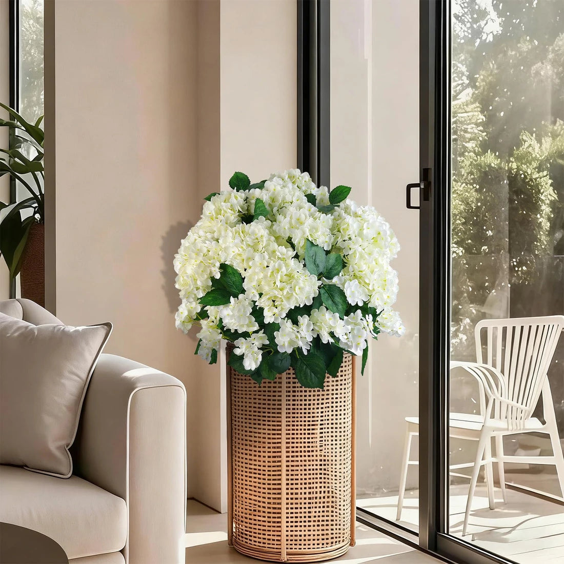 White artificial hydrangeas styled indoors in a tall woven basket