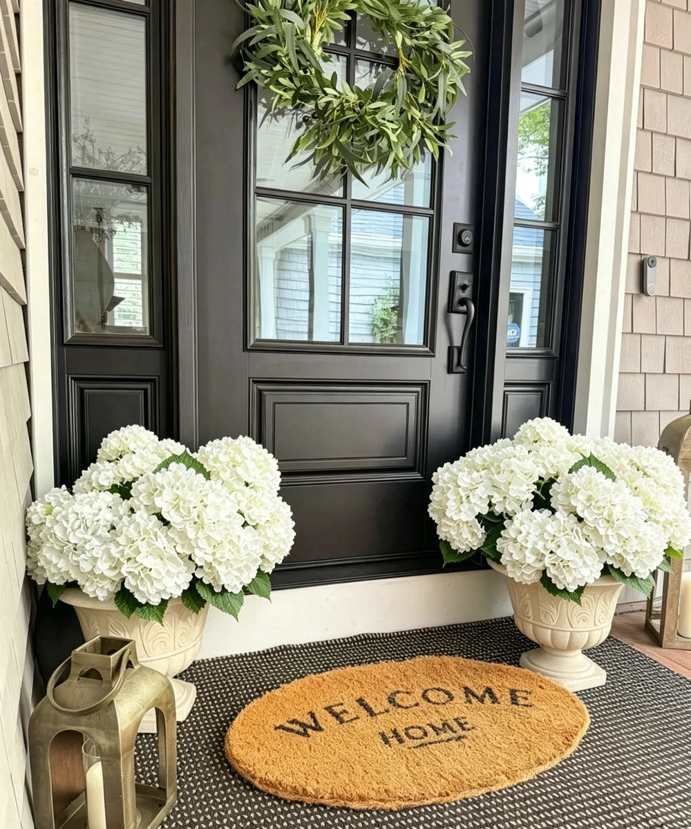 White artificial hydrangea arrangement in front porch urns